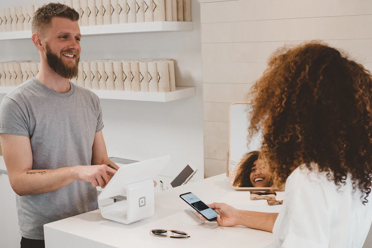 Friendly staff member helping a customer at a service counter