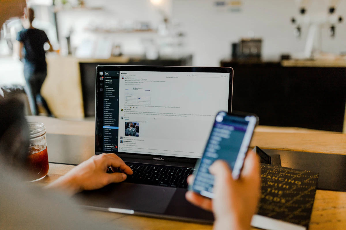 Professional reviewing business records on a laptop and phone