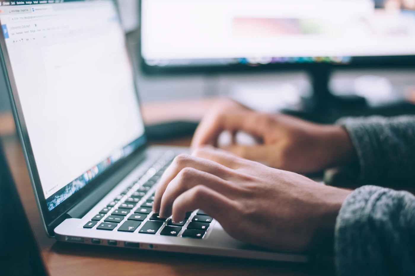 Hands typing on a laptop keyboard during data entry work